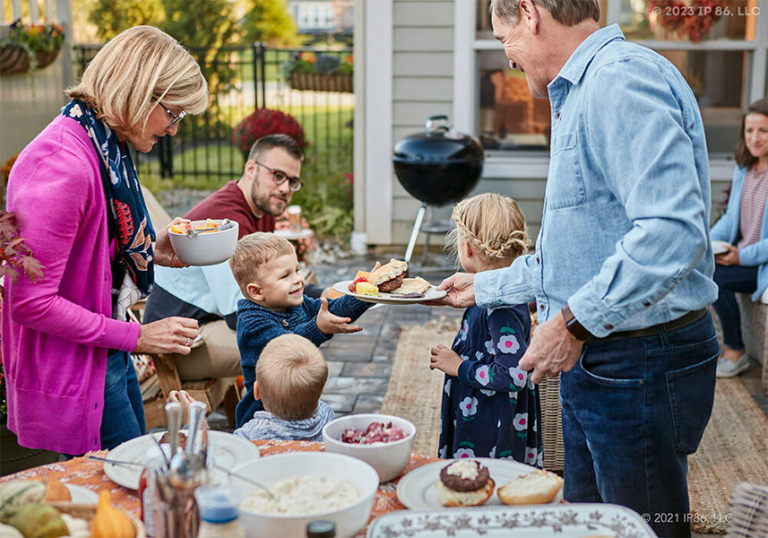 A family with young children grilling