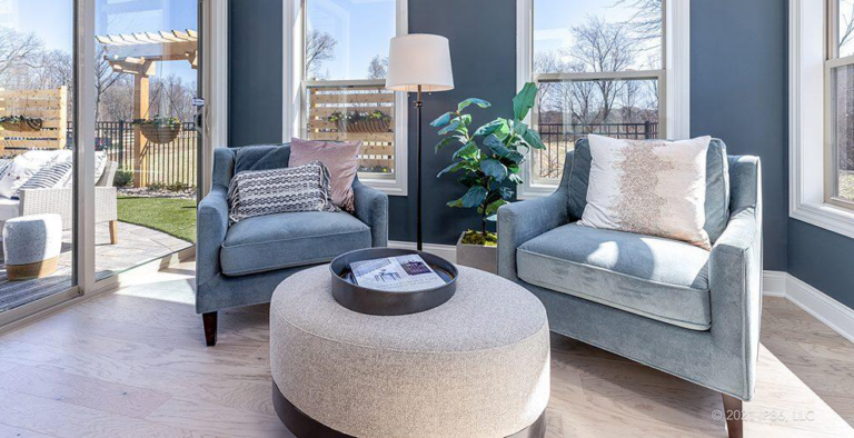 two oversized chairs and an ottoman in a living area